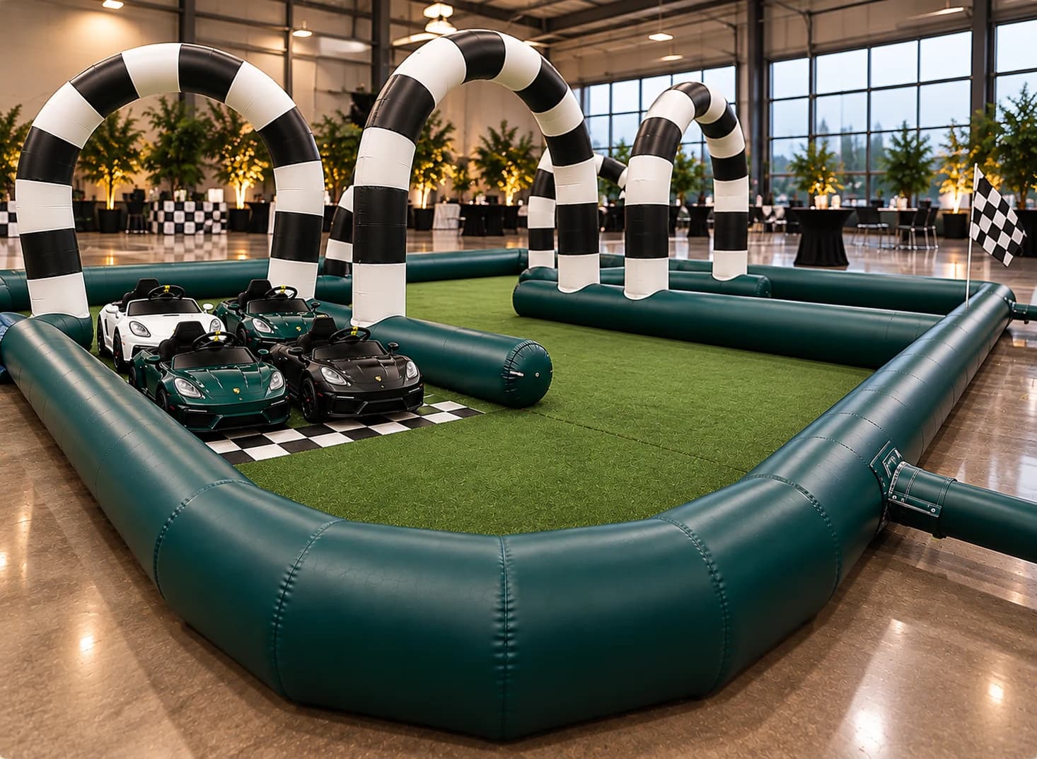 Mini Grand Prix indoor event setup with four miniature cars on the checkered starting grid